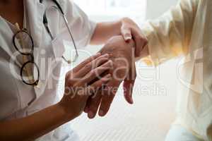Midsection of doctor examining senior man in nursing home