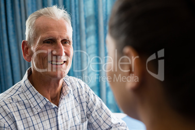 senior man interactin with female doctor in retirement home