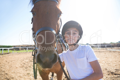 Rider girl standing with a horse in the ranch