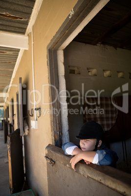 Girl leaning on wall in the stable