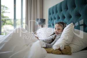 Girl using mobile phone on bed in bedroom