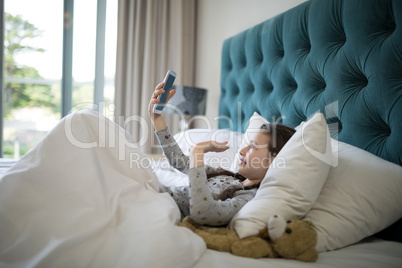 Girl video calling on mobile phone in bedroom