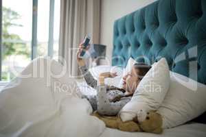 Girl video calling on mobile phone in bedroom