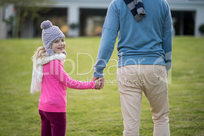 Daughter and father holding hands in the garden