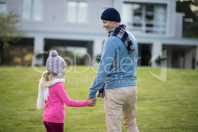 Daughter and father holding hands in the garden