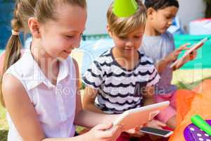 Children using tablet computer during birthday party