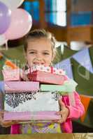 Birthday girl holding various gift boxes at home