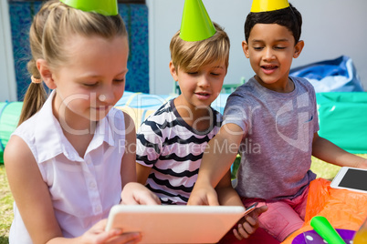 Children using digital tablet during birthday party