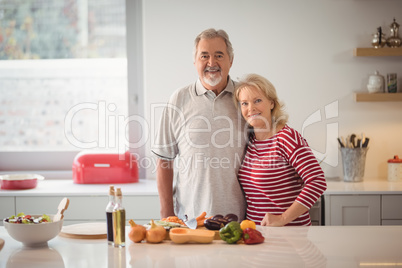 Smiling senior couple standing together in kitchen