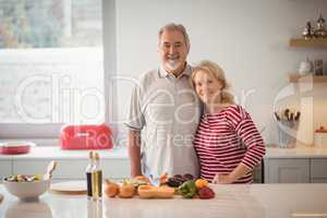 Smiling senior couple standing together in kitchen