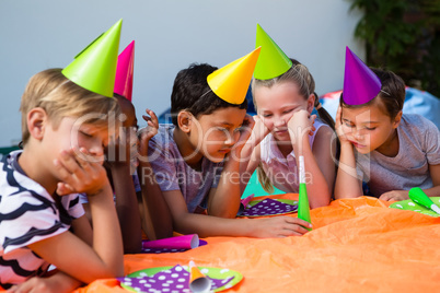 Children with hand on chin during birthday party