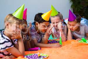 Children with hand on chin during birthday party