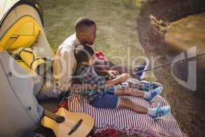 Father and son fishing together in park