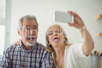 Senior couple taking a selfie in the kitchen