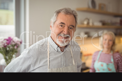 Smiling senior man standing in kitchen