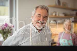 Smiling senior man standing in kitchen