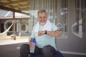 Senior man checking time on wristwatch after work out