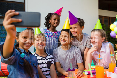 Happy children taking selfie during birthday party