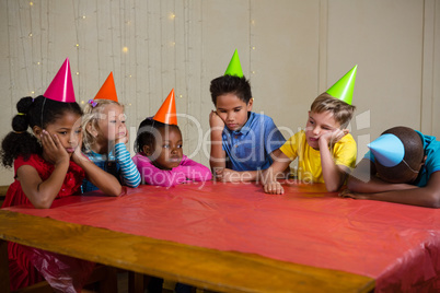 Tired children sitting at table