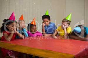 Tired children sitting at table
