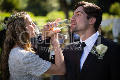 Bride and groom having champagne during wedding