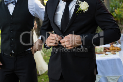 Bridegroom buttoning a wedding suit