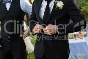 Bridegroom buttoning a wedding suit