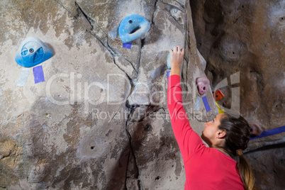 Determined woman practicing rock climbing
