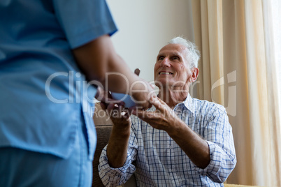 Female doctor serving food to senior man at retirement home