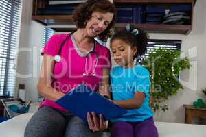 Physiotherapist sowing medical report to girl patient