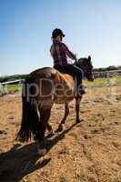 Girl riding a horse in the ranch