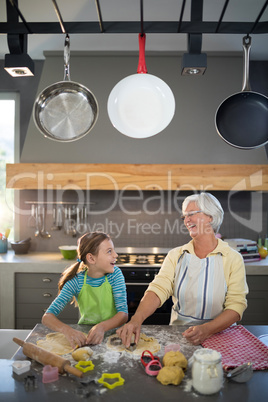 Grandmother and granddaughter cutting dough with a cookie cutter