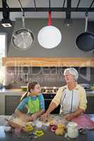 Grandmother and granddaughter cutting dough with a cookie cutter