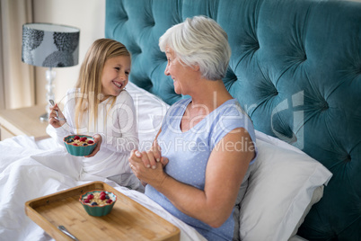 Granddaughter and grandmother interacting while having breakfast