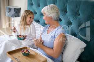 Granddaughter and grandmother interacting while having breakfast