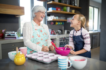 Smiling grandmother and granddaughter looking at each other