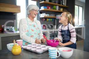 Smiling grandmother and granddaughter looking at each other