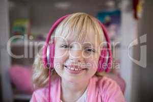 Cute girl listening to pink headphones