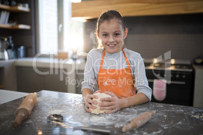 Little girl holding dough in her hand