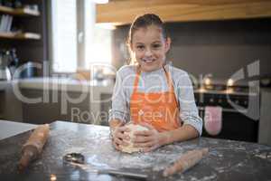 Little girl holding dough in her hand