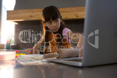 Girl using laptop in kitchen