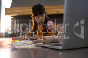 Girl using laptop in kitchen