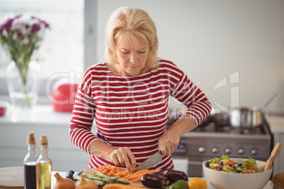 Senior woman chopping vegetables