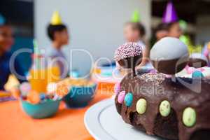 Close up of birthday cake with children in background