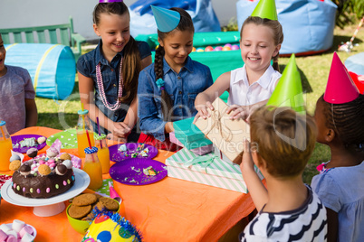 Cheerful girl receiving gifts from friends