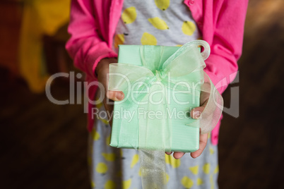 Birthday girl holding gift box at home