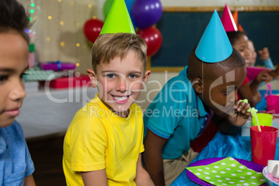 Portrait of boy sitting by friends