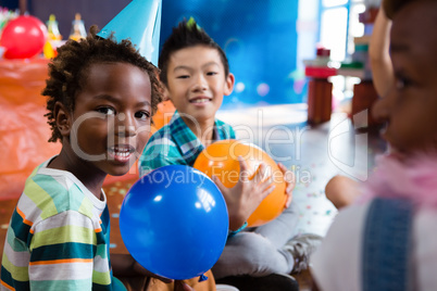 Portrait of children playing with balloon