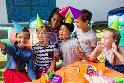 Cheerful children taking selfie during birthday party