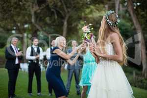 Rear view of bride holding flower bouquet